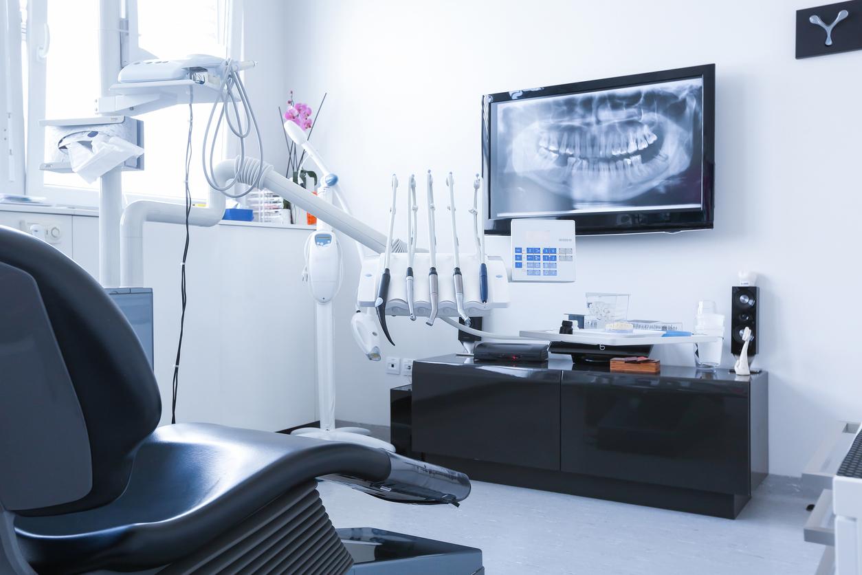 Pristine dentist office shows room with modern technology and oversized X-ray on the wall